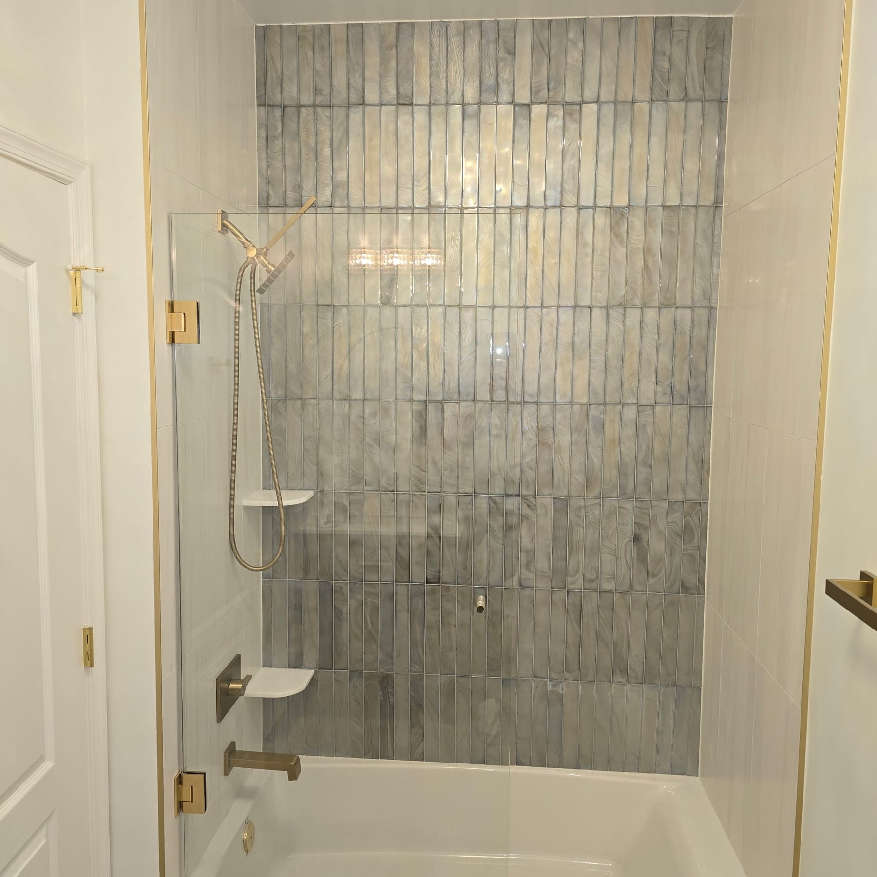 Vertical iridescent pearl-tile shower with brushed-gold fixtures